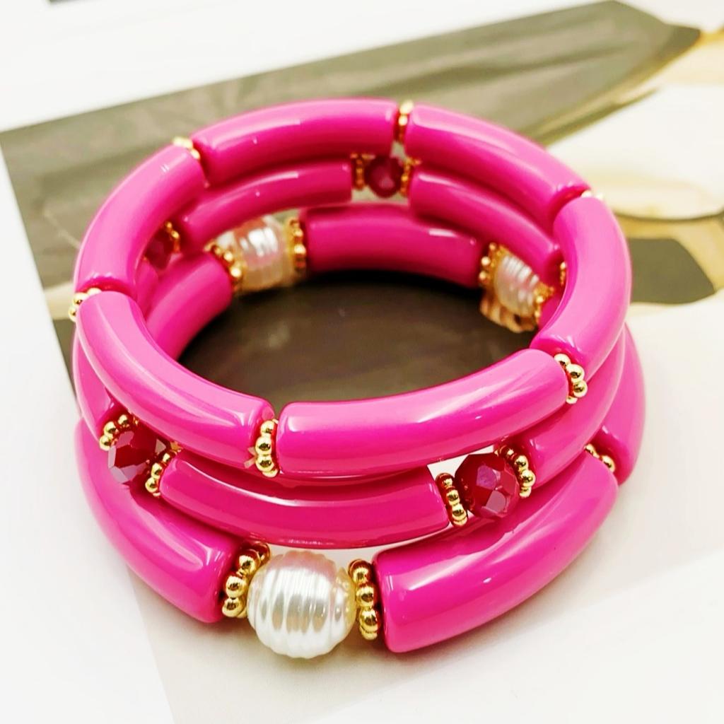 A set of three acrylic tubes connected by small golden flowers, adorned with crystal and faux pearl decorations, suitable for a lady's party.