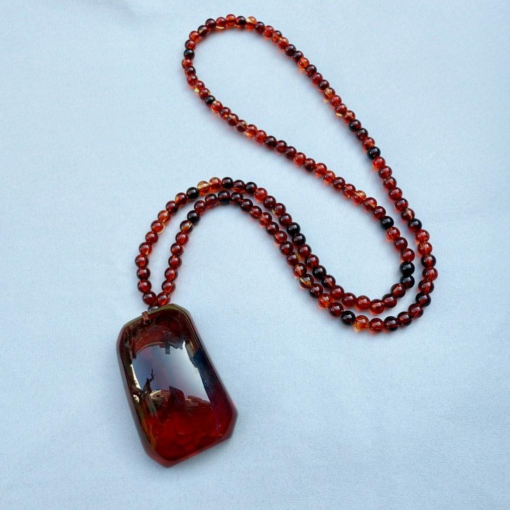  Bursztynowy Vintage Bursztynowy Wisiorek Naszyjnik Wiszący Dla Mężczyzn I Kobiet Z Krwistoczerwonymi Perłami. Naszyjnik Spokojny Urok na Łańcuszku w Etnicznym Swetrze.