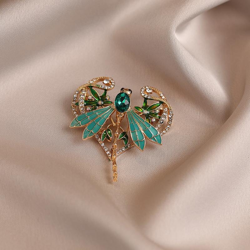 Die exquisite grüne Libellenbrosche mit Öltropfen strahlt ein Gefühl von Luxus aus. Sie ist eine hochwertige smaragdgrüne Insektenbrosche.
