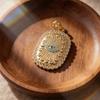 Ciondolo Occhio Blu Turco: Forma Ovale con Motivo Solare, Placcatura in Oro e Intarsio di Diamanti su Catena per Clavicola.