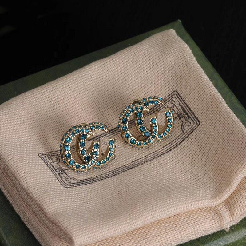 Gu Jia Doppeltes G Blaue Strass-Steckohrringe - Vintage Messing-Design mit Silbernadel