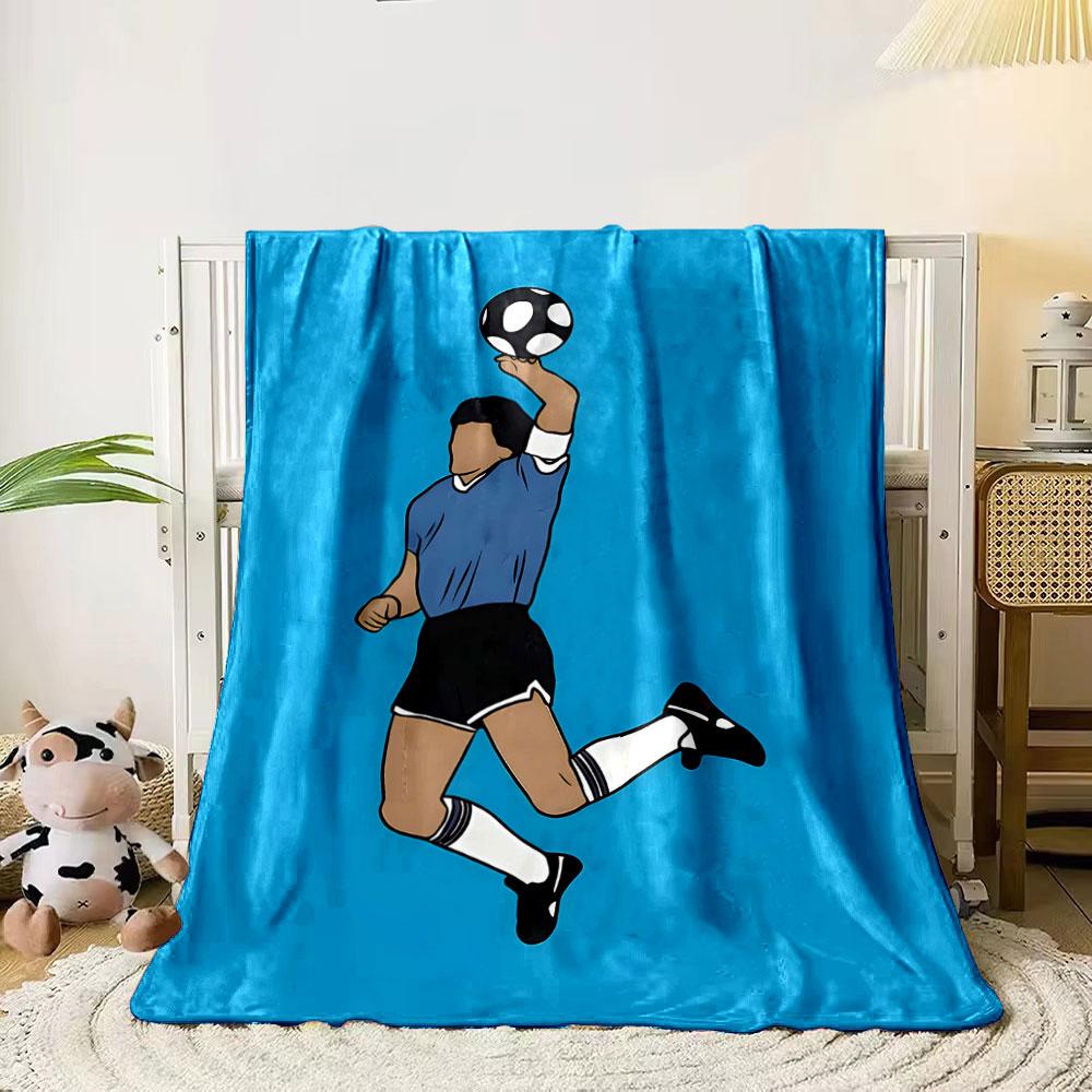 A person jumps in a blue kit, holding a black-and-white soccer ball. for all seasons blanket lunch break throw gift 80cm x 120cm