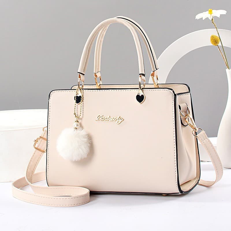 Bolsa pequena transversal decorada com bola de pelo, elegante