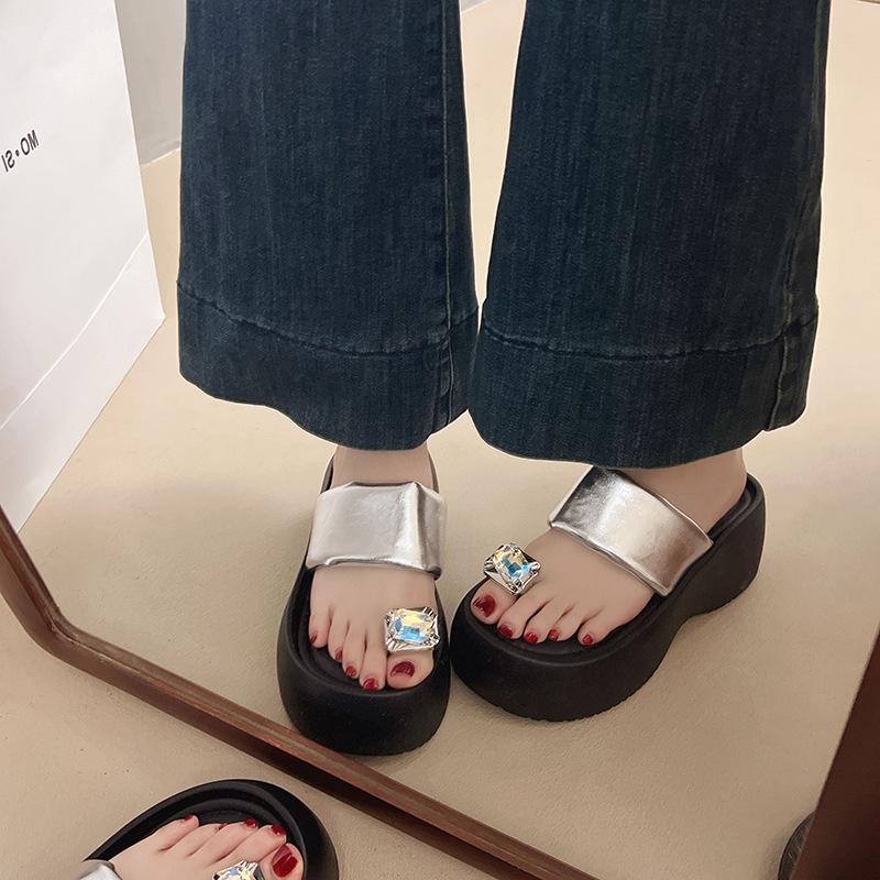 In the Summer of 2025, the New Rhinestone Cover Toe Sponge Cake with Thick Bottom Slope Heel and Cool Slippers Are Worn by Women.