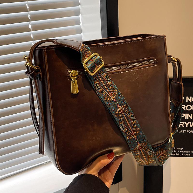 

Цього року популярними маленькими сумками є жіночі осінні та зимові універсальні 2024 нова ретро широкосмугова сумка через плече жіноча сумка-відро. темно-коричневого кольору