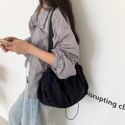 Sac bandoulière léger et décontracté en nylon plissé avec cordon de serrage, nouveau modèle de sac à bandoulière, sac messager femme au design original et pratique.