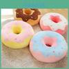 Almofada de pelúcia em formato de donut, fofa e ideal para decoração de casa e assento confortável.