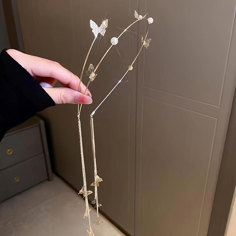 Ein Stirnband mit Metall-Schmetterlingsquaste, verziert mit künstlichen Perlen - ein rutschfestes Stirnband für langes Haar, ein stilvolles Accessoire für Frauen.