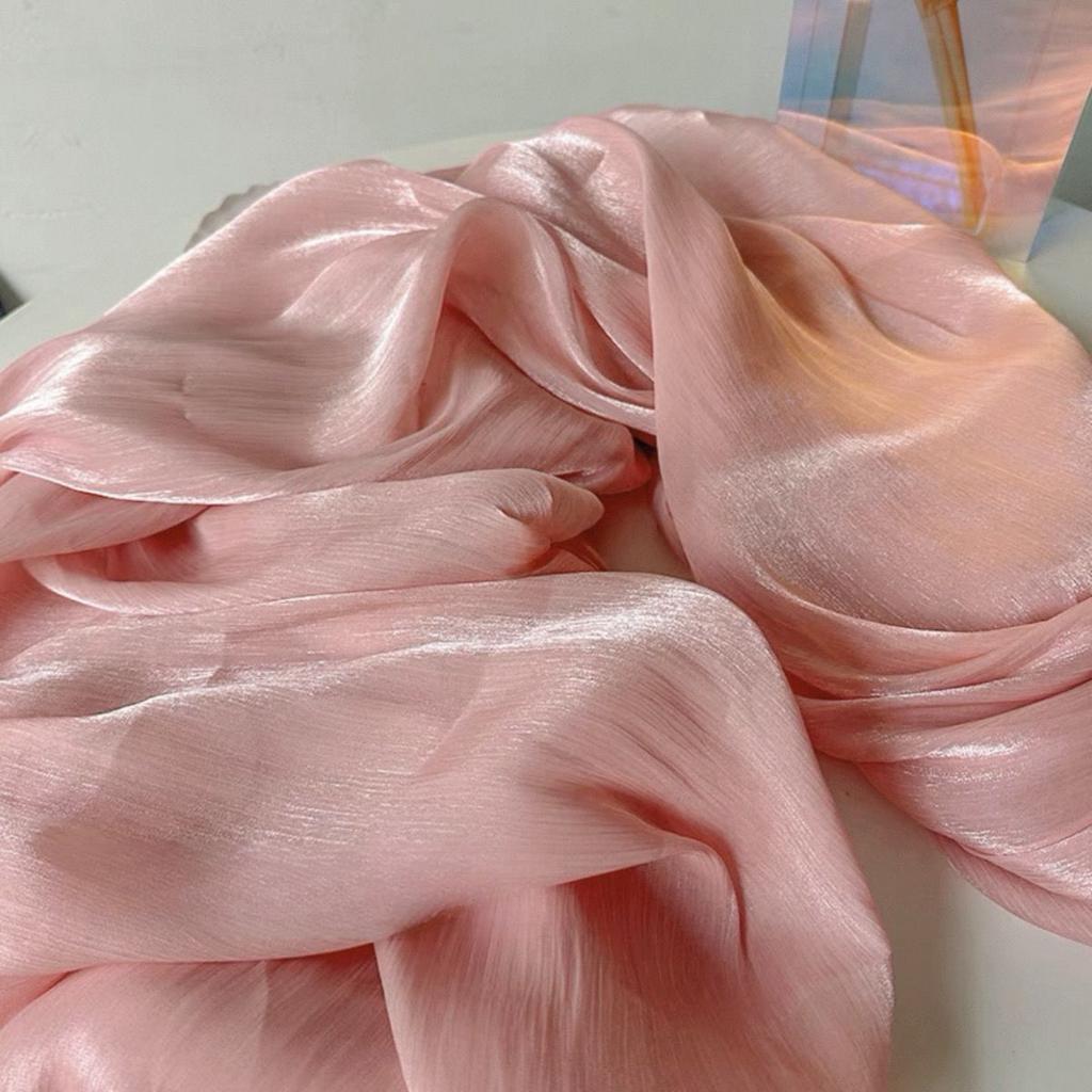 Soft shiny creased organza fabric with a smooth texture suitable for wedding dresses formal gowns and designer clothing fabrics