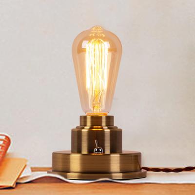 Cerdeco TBL17, eine robuste, industriell inspirierte Schreibtischlampe mit einer einzelnen Lichtquelle im Antikstil und einem bronzebeschichteten Sockel, der die nackte Glühbirne betont.. Perfekt