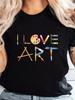 Damen 'Ich liebe Kunst' Grafik-T-Shirt - Lässiges schwarzes Kurzarm-T-Shirt mit buntem Bleistift- und Paletten-Print