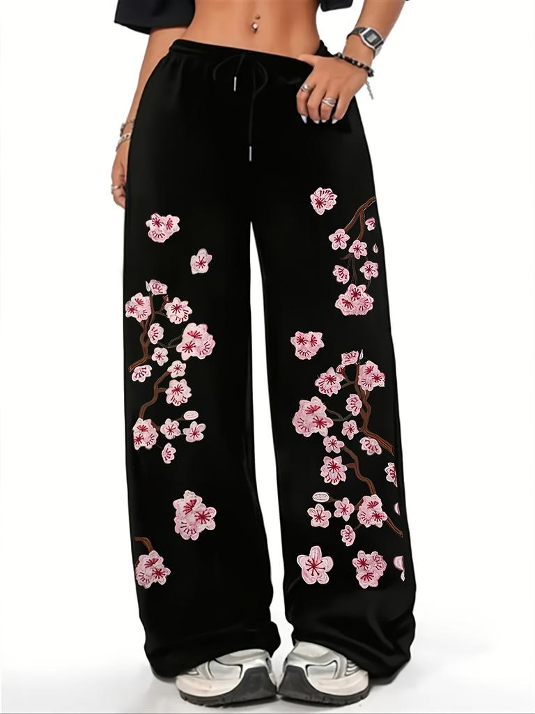 Women's black and pink jogging pants with a cherry blossom print inspired by Japanese floral designs