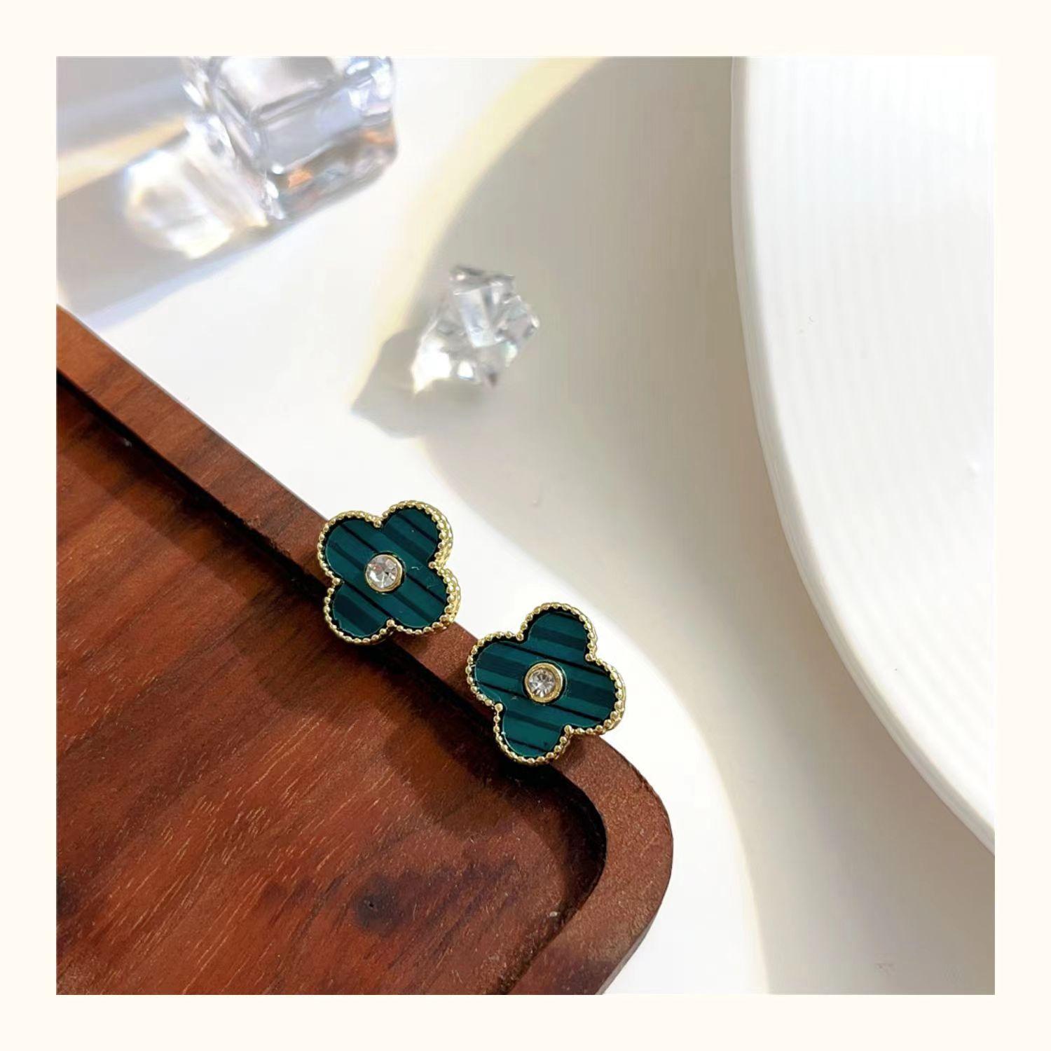 

Старшее чувство красочного четырехлистного клевера с бриллиантовыми серьгами. Изысканные модные темпераментные женские серьги с цветами. зелёный