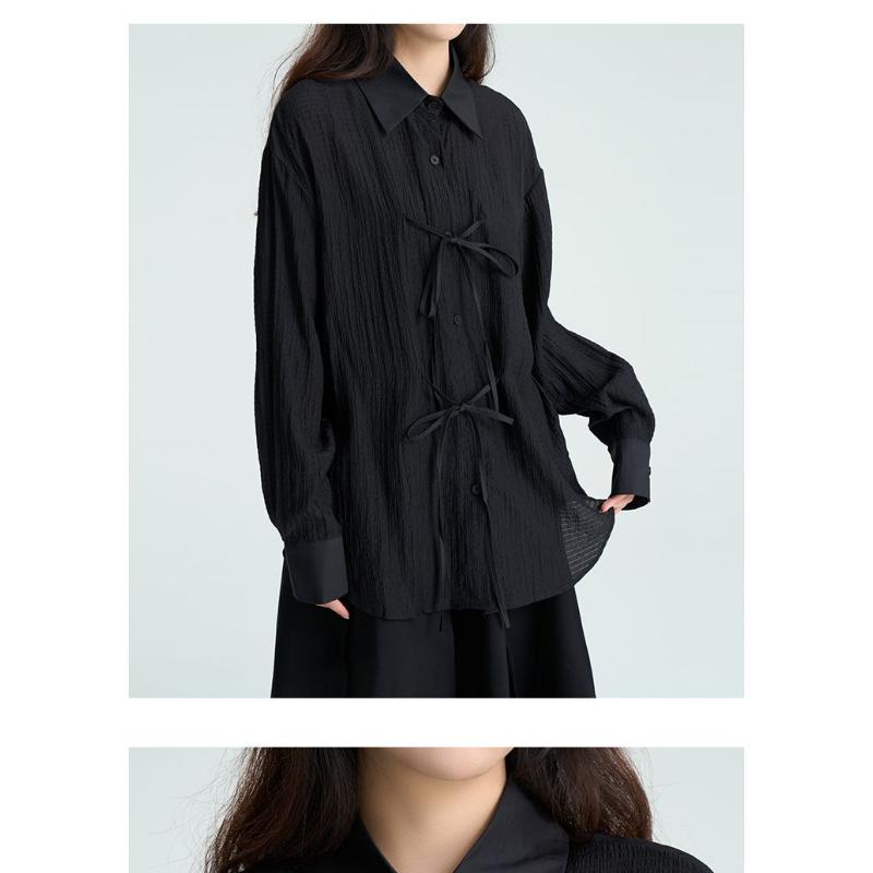 Camicia da donna nera testurizzata, casual, ampia, a maniche lunghe, con nodo sul davanti e bottoni.