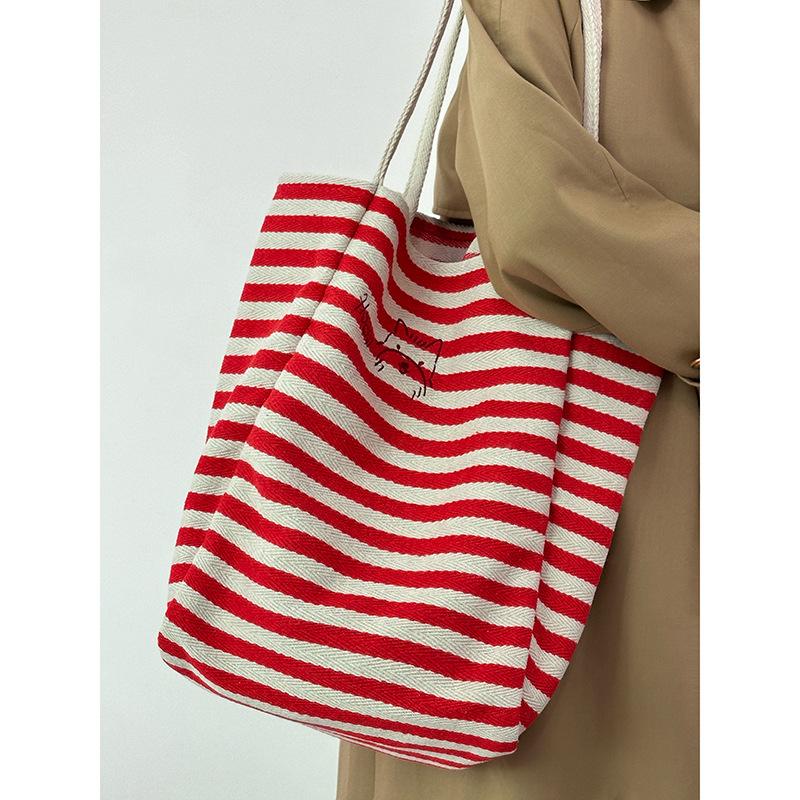 Large capacity striped canvas bag women's 2025 new niche embroidery lazy wind commuter portable shoulder tote bag
