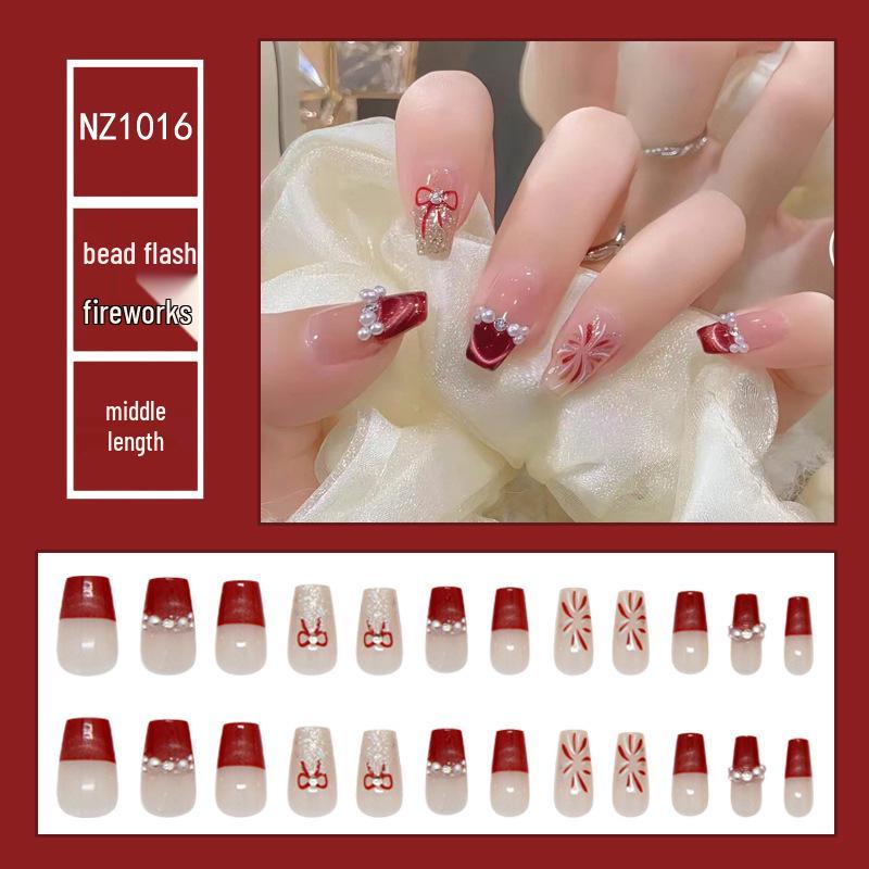 

Красные ногти «кошачий глаз» с накладными типсами Т-образной формы средней длины и стразом-бантом