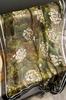 An Elegant Scarf with a Floral Pattern On a Background In Shades of Green and Brown
