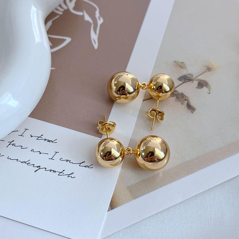 

Минималистичная мода для通勤: Металлические серьги-шарики в трендовом холодном стиле золотой