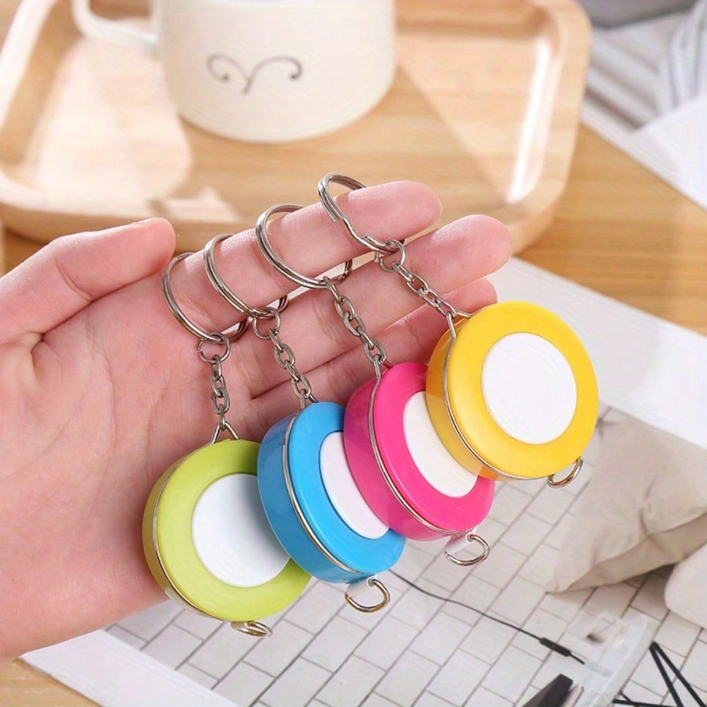 A Stylish Keychain Measuring Tape In Vibrant Colors, Featuring A 1.5-Meter Retractable Design, Perfect for Measuring Clothing Sizes