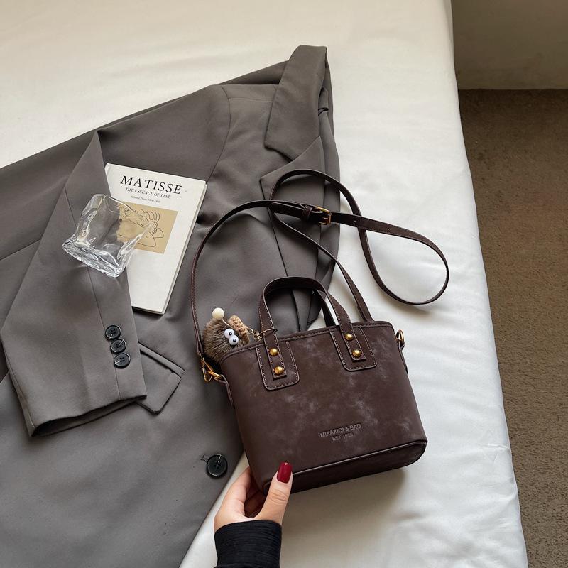 

Замшевая сумка женская осенне-зимняя универсальная 2025 новая матовая ретро сумка через плечо, популярная портативная сумка-ведро темно-коричневого