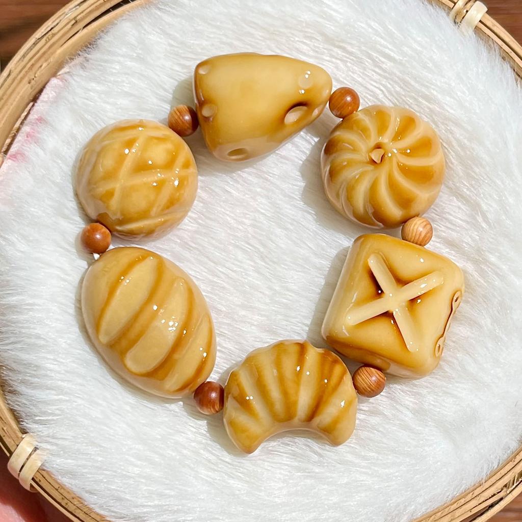 Der gleiche Stil wie der Little Red Shop: Holzkohle-gebranntes Elfenbein-Fruchtschnitzerei-Armband, süßes brotförmiges Elfenbein-Frucht-Kulturspielzeug-Armband für