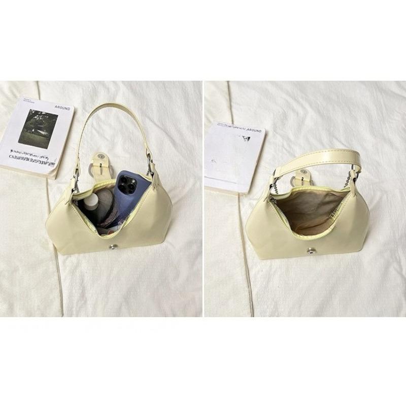 Solid color crescent-shaped hobo bag with metal D-ring embellishment, elegant underarm bag, versatile women's handbag for dates and everyday wear.