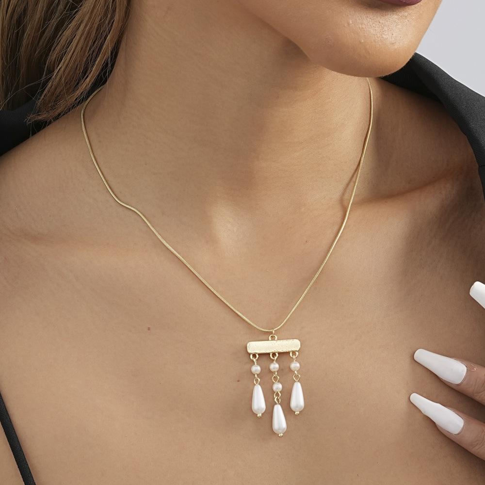 

Трендовое зимнее золотое колье 2023 года с выразительной жемчужной подвеской и ультрамодными кисточками