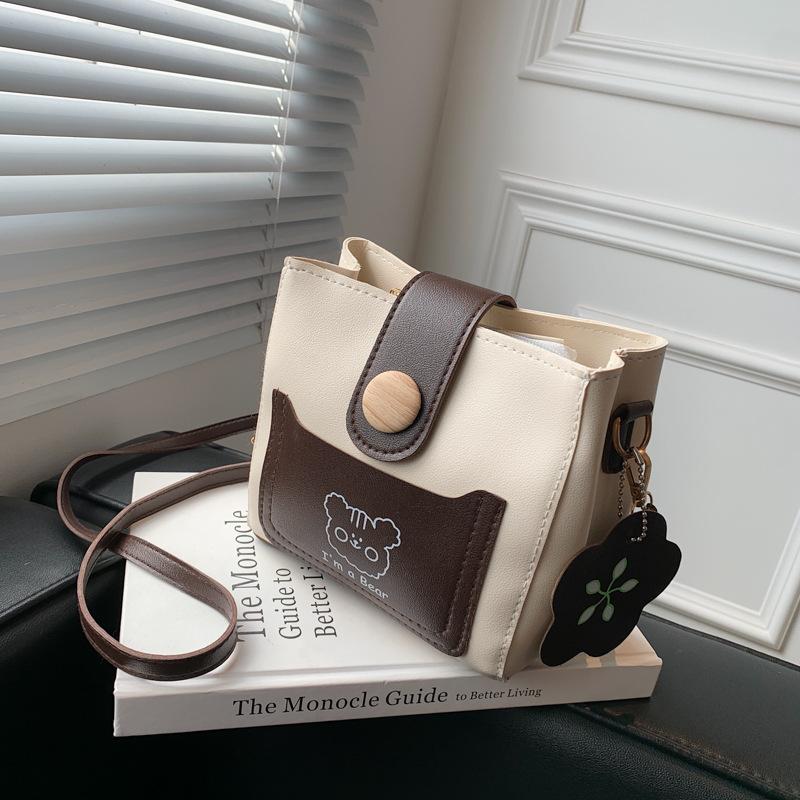 

Premium sense bucket bag small bag women s 2025 autumn new niche shoulder bag versatile cartoon contrasting messenger bag темно-коричневого