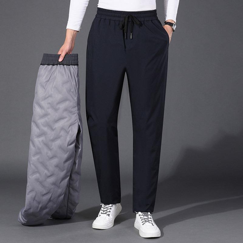 Papa porte un pantalon d'hiver en duvet et porte un pantalon thermique de sport business casual à taille haute. Pantalon en duvet d'oie droit pour hommes d'âge mûr