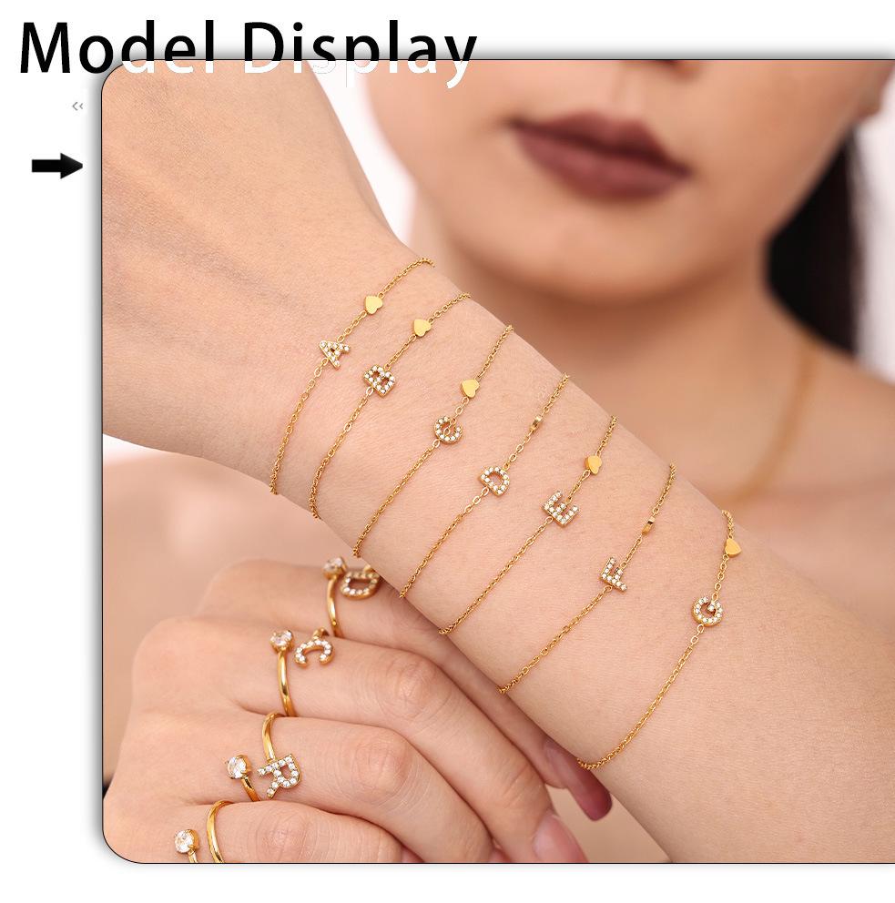 Oumeika Titanium Steel Jewelry Set: 26 Zircon-Inlaid Letters, PVD Gold-Plated Necklace, Bracelet, Earrings, and Ring.