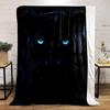 A sleek black panther with glowing blue eyes in a dark background. for all seasons blanket lunch break throw gift