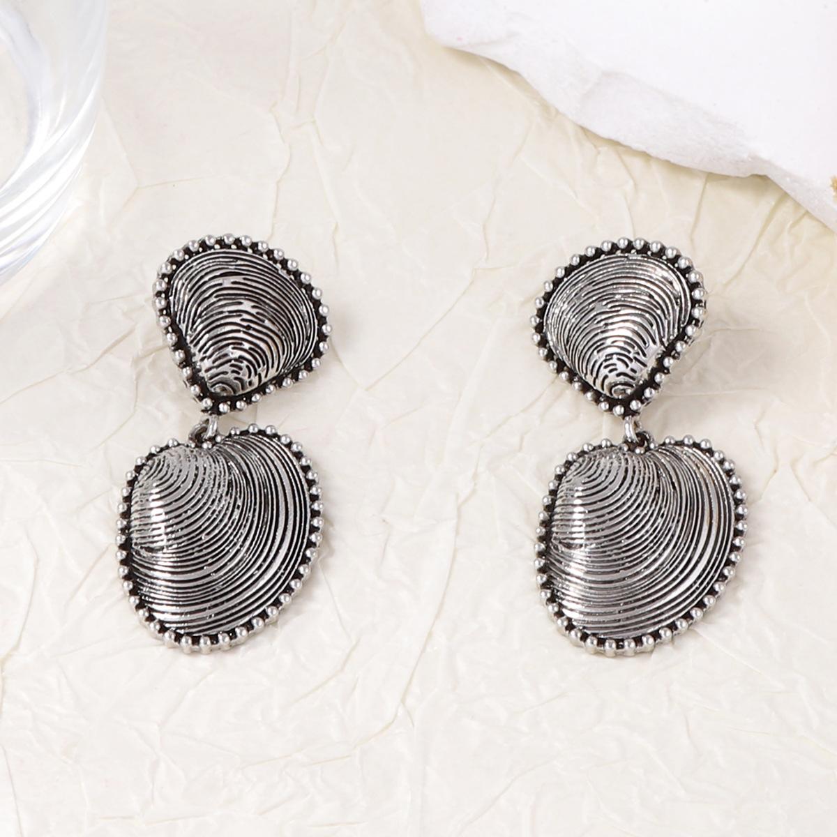 

The earrings are a high-end design for women, featuring an alloy aged scallop shell with a unique texture, and are a light luxury vacation accessory