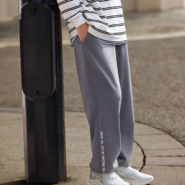 Li Ning Seria Lifestyle Sportowy Nadruk Logo Elastyczne Średnio Wysokie Zwężane Wygodne Oddychające Dzianinowe Spodnie Sportowe Spodnie Męskie Szaroróżowe AKLTB23-4