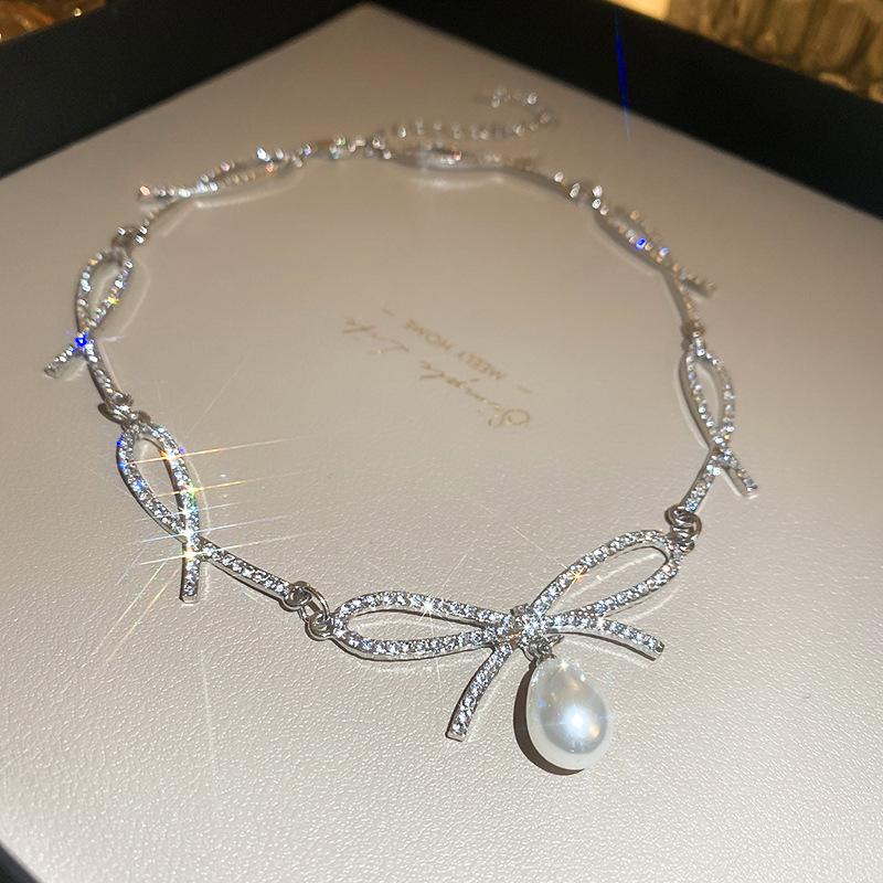 

Элегантное колье-чокер с жемчугом и бантом из стразов