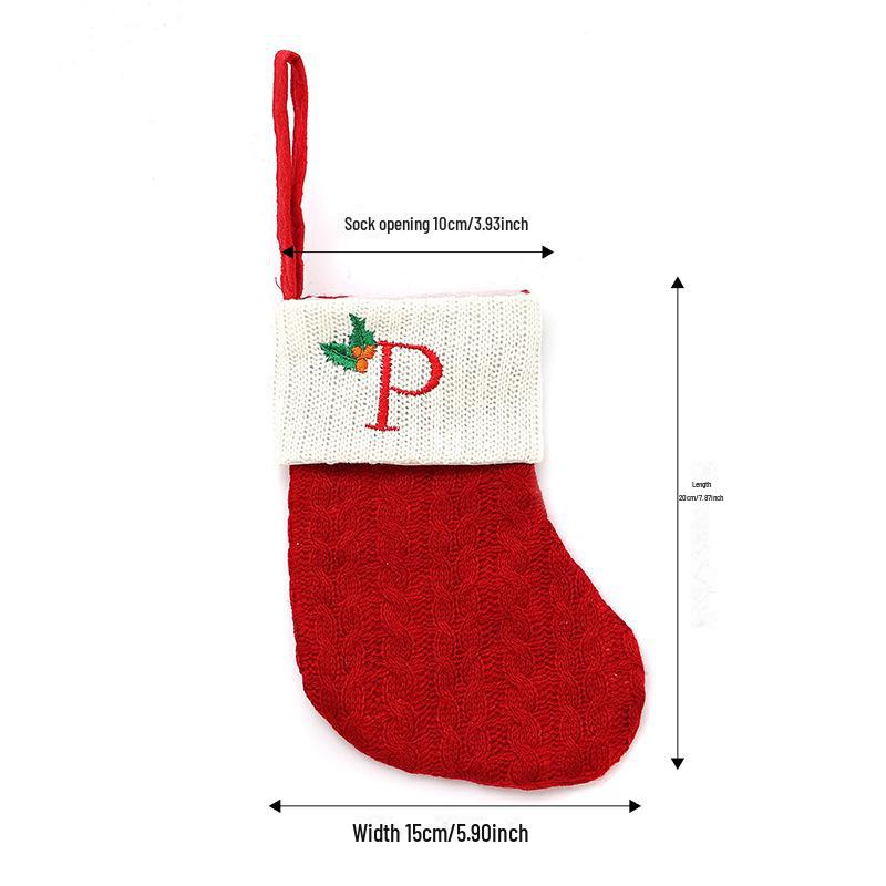 Weihnachtsdekorationen: Rote gestrickte Kinderstrümpfe mit gestickten Buchstaben