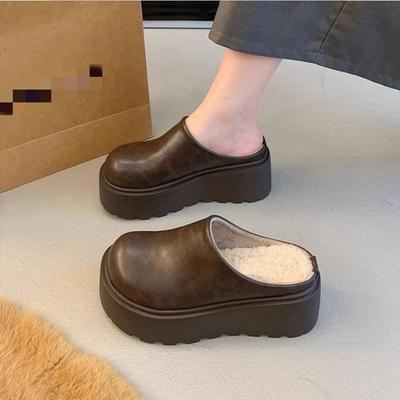 Una persona minuta aumenta l'altezza della testa della borsa e delle mezze pantofole, e indossa le nuove pantofole Birkenstock termiche in velluto a suola spessa in autunno.