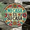 2D Flach - Ein rundes Schild mit einem spanischen Satz und floraler Aluminiumkunst. Dieses lebendige, rustikale Metall-Wandbild mit der Aufschrift 'Mi Casa Es Su Casa' dient
