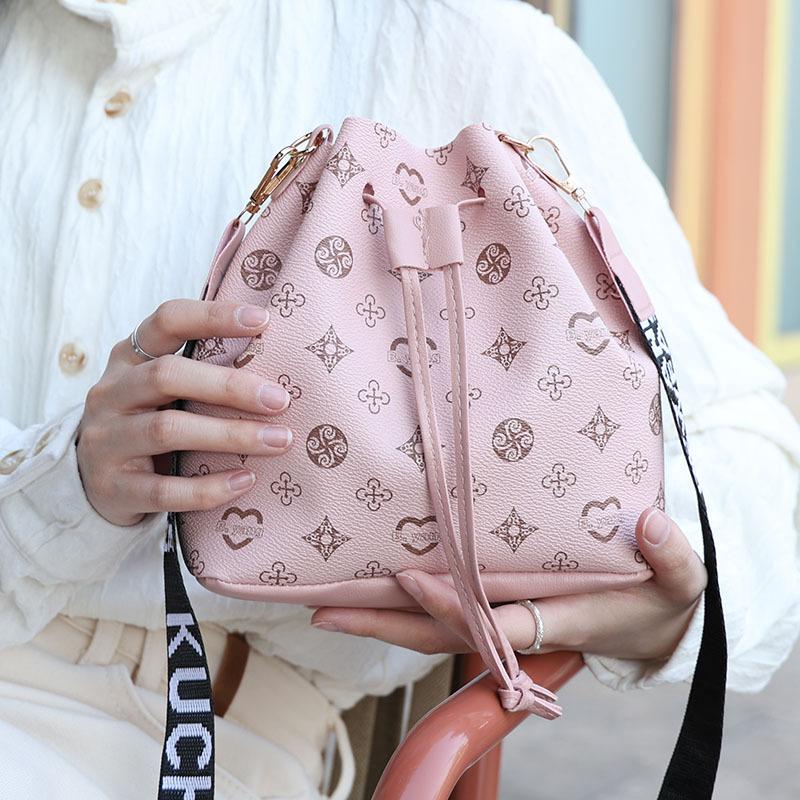

New women s drawstring bucket bag fashionable letter wide shoulder strap commuter bag trendy shoulder bag one piece розовый