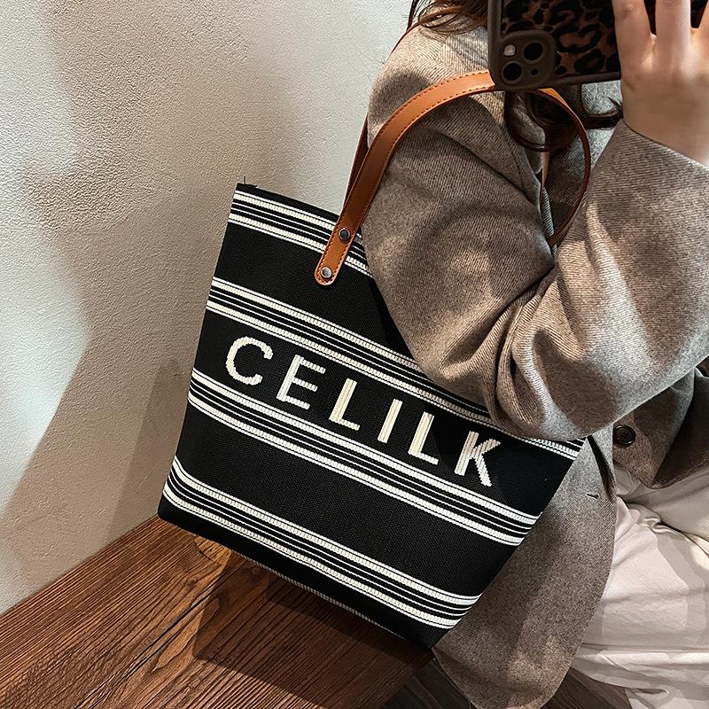 

2025 зима корейская версия интернет-знаменитостей с той же большой сумкой-тоут в полоску, универсальная, повседневная, для поездок на работу, подмышечная сумка через плечо для женщин 27*15*31 чёрный