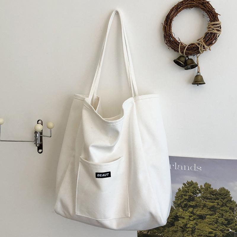 Bolsa de lona com letra de cor sólida 2026 nova ins grande capacidade simples moderna bolsa de ombro versão coreana bolsa tote artística
