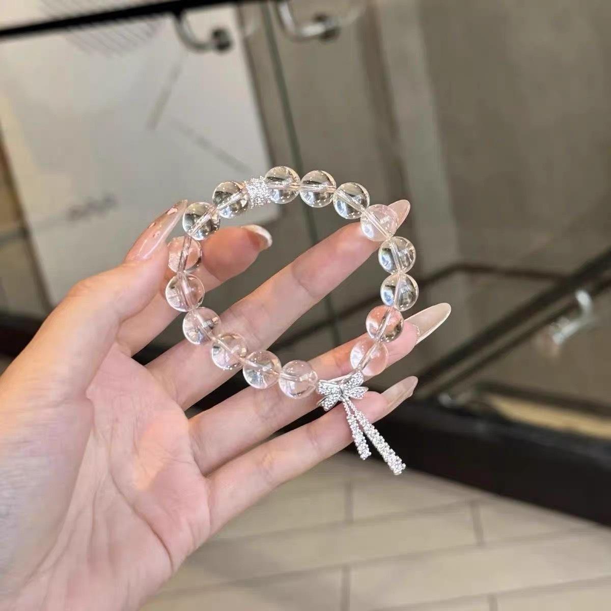 

Sweetly Transparent White Crystal Hand Bracelet with Tiny Fringed Bow Accents, A Truly Enchanting String Jewelry for Ladies.