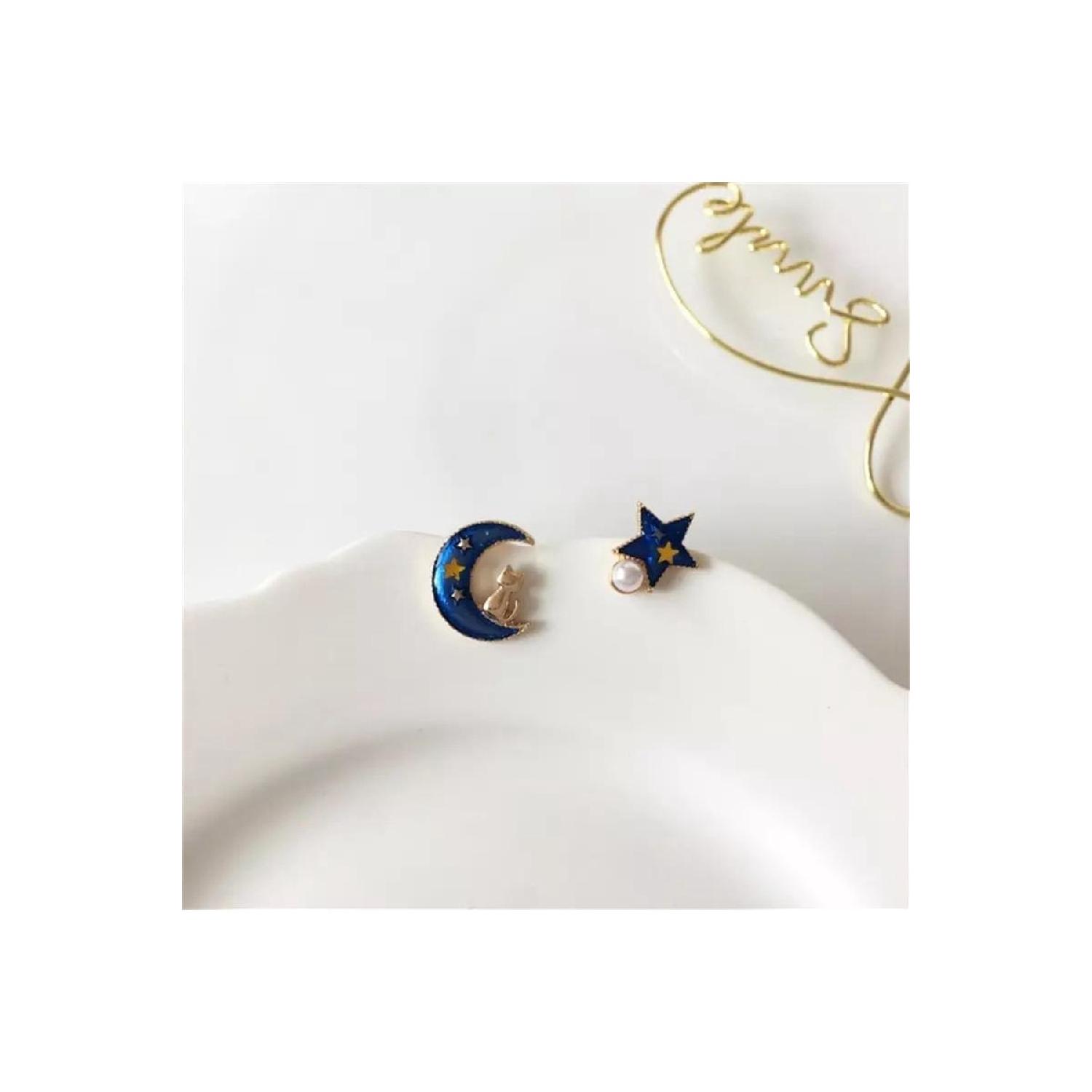 

Кот, сидящий на голубой луне и серьгах со звездами