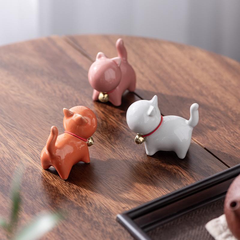 Eine kleine niedliche Katze im chinesischen Stil als Teehaustierfigur mit einem Keramik-Katzenpinselständer