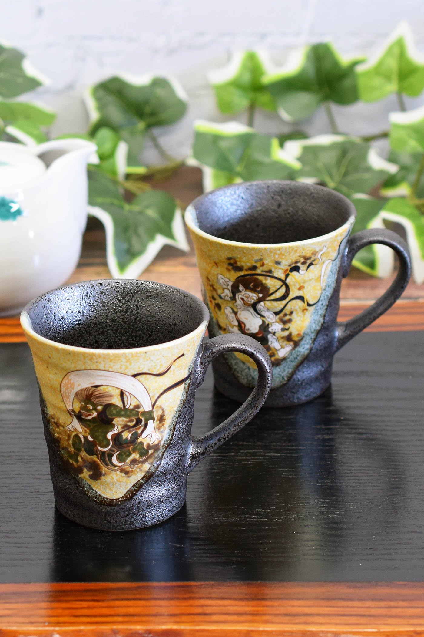 

Waza no Kura Stylish Pair of Kutani Ware Mugs Featuring the Wind and Thunder Gods. High-Quality Pottery. Made in Japan.