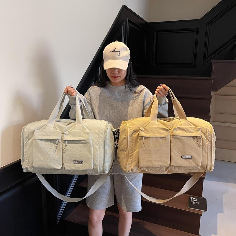 Trocken- und Nassfach Kurzreisetasche Damenhand legt eine Duffeltasche mit großem Fassungsvermögen und mehreren Fächern zur Aufbewahrung für schwangere Frauen zur Entbindung aus