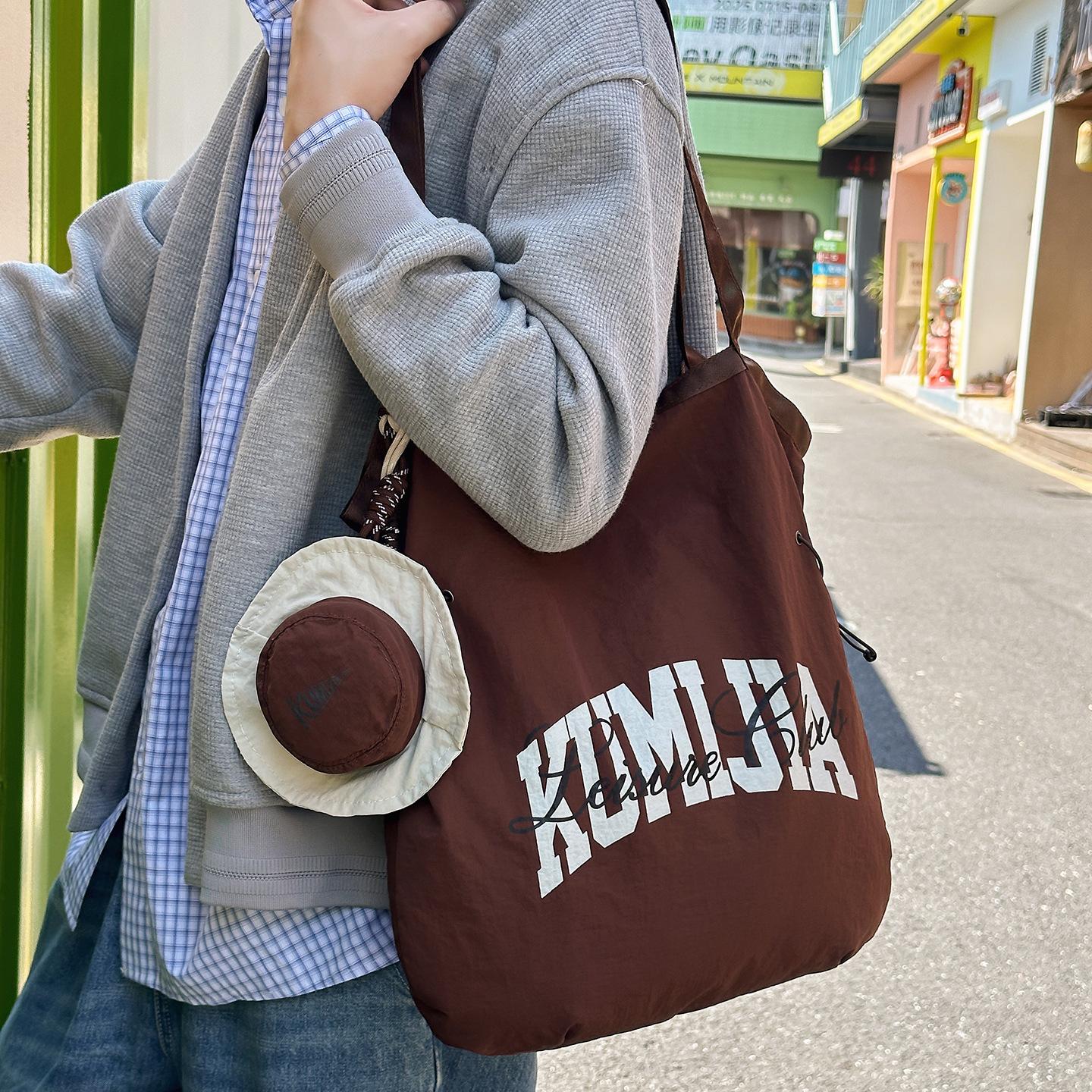 

Korean version of casual lazy style underarm bag women s 2025 new nylon cloth bucket bag letter print shoulder bag коричневый