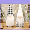 Kerstdecoratie: pluche kerstmanfiguur met zwart-wit geblokt patroon voor de feestdagen in huis.