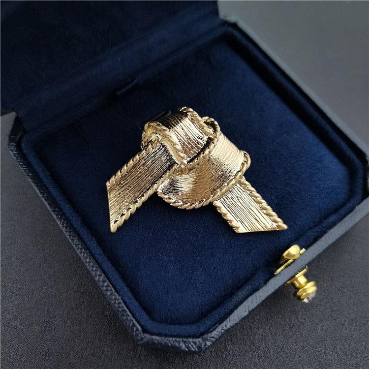 Gold plated alloy knot shaped brooch with neutral and cool style, fashionable and simple women's accessories