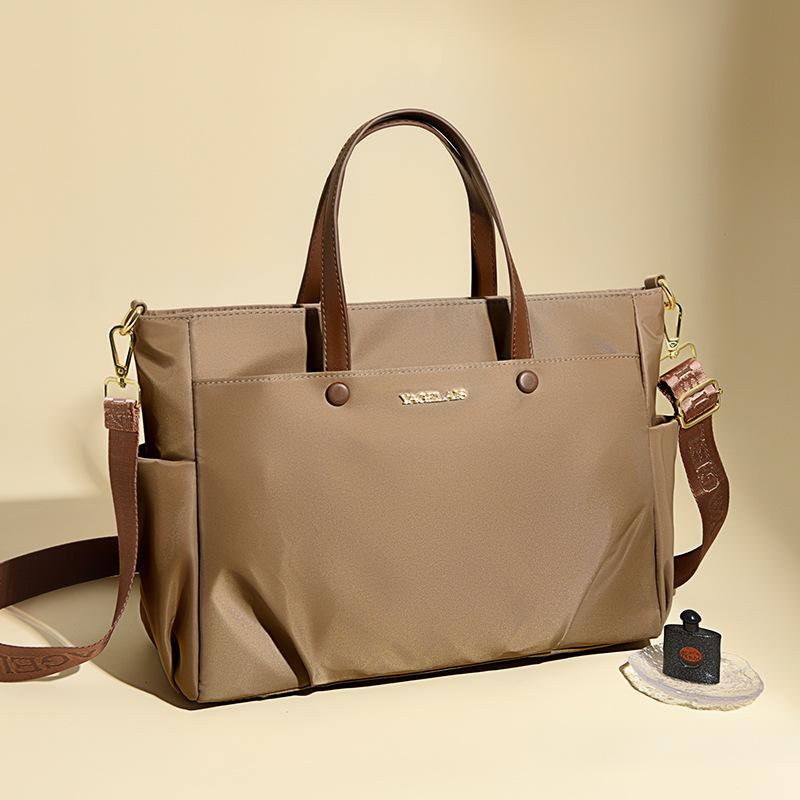 A Laptop Bag, A Lady Carrying A Business Briefcase and Slung A Commuter Tote Bag Across Her Shoulder