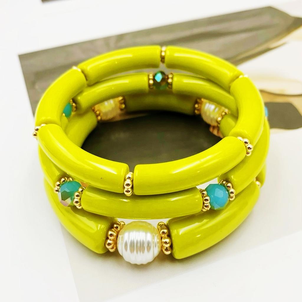A set of three acrylic tubes connected by small golden flowers, adorned with crystal and faux pearl decorations, suitable for a lady's party.